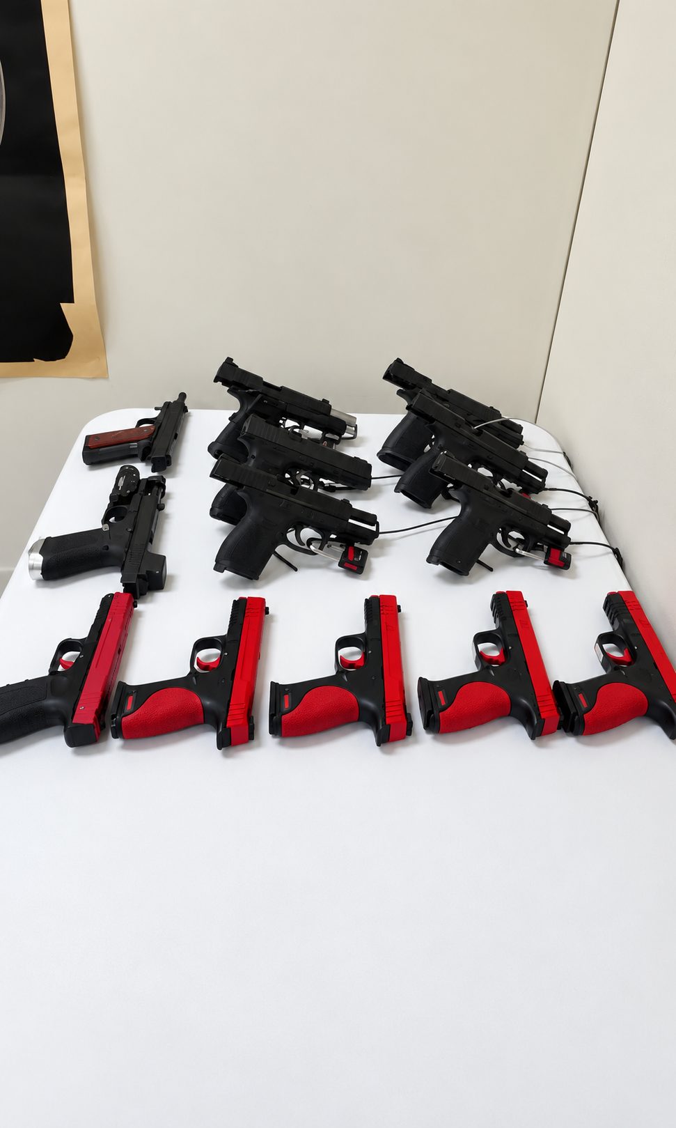 Training handguns and red training pistols laid out on a table